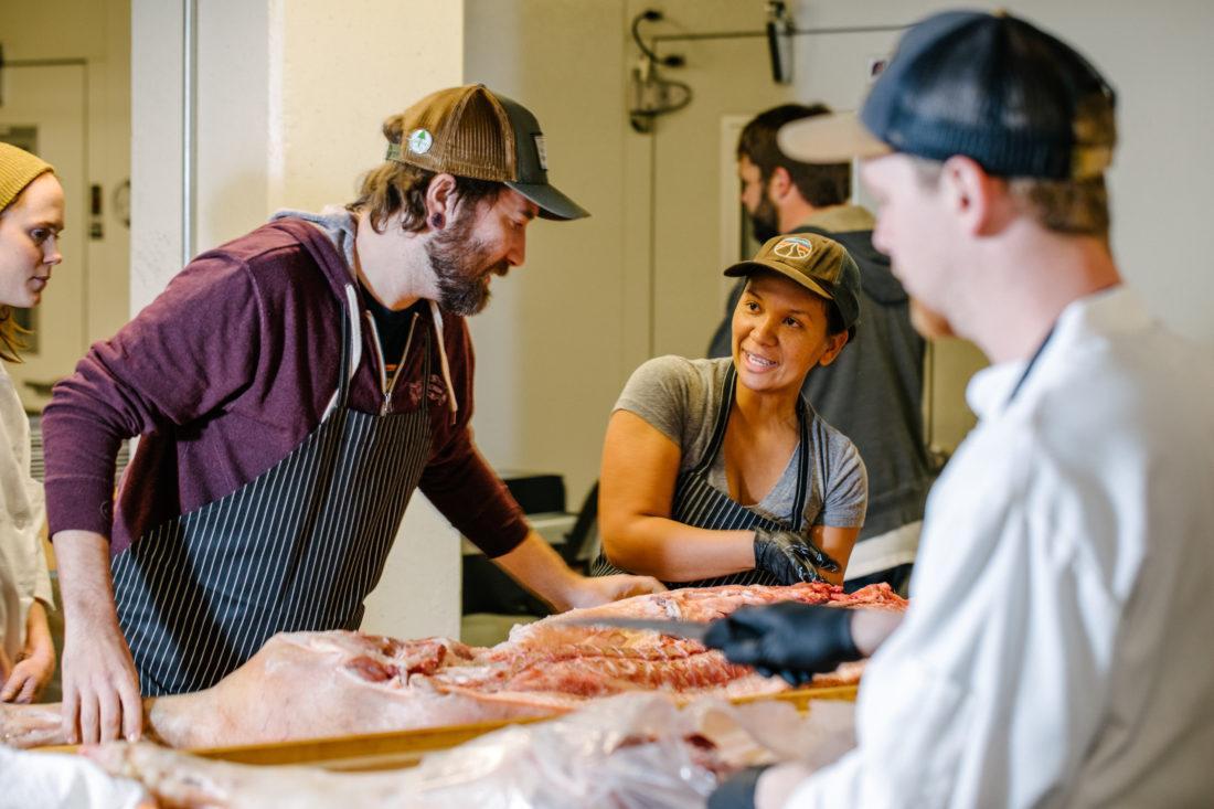 a man and women discuss over uncut pieces of meat