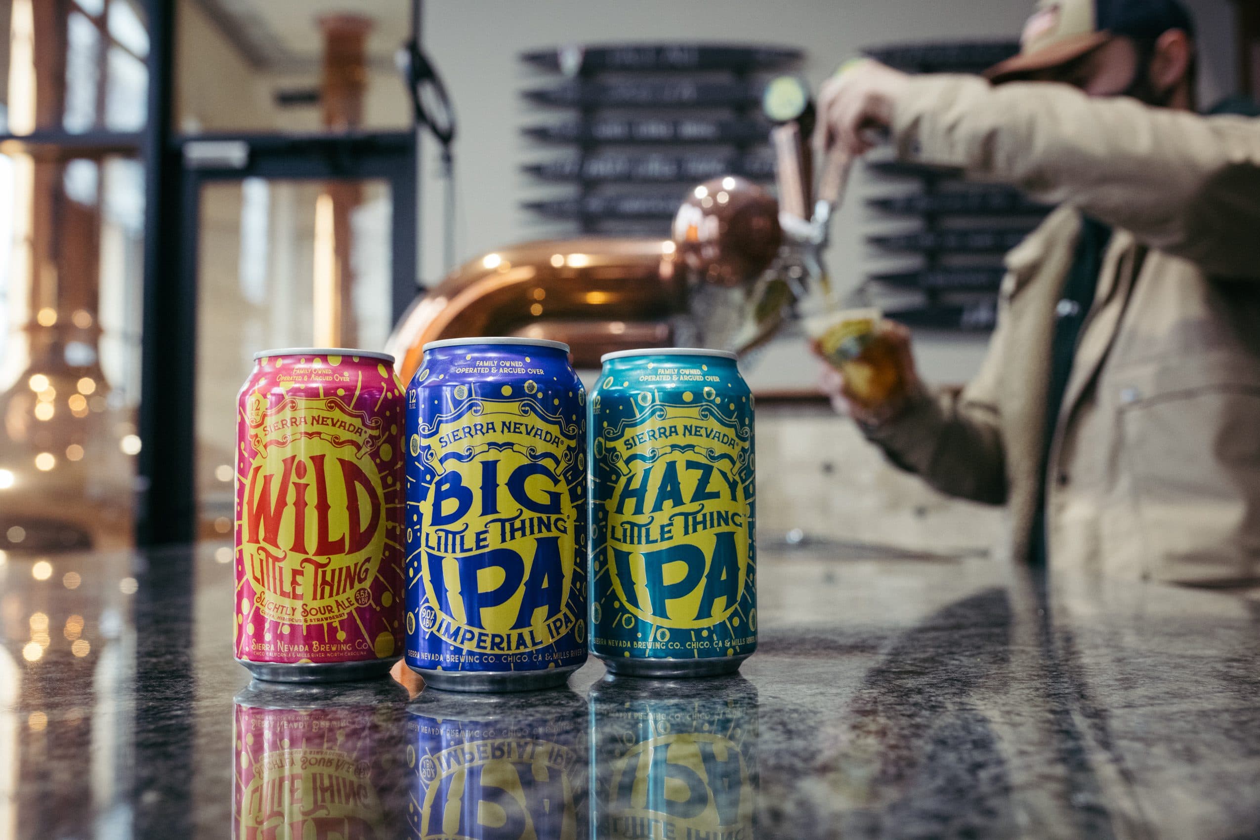 Granite countertop in a taproom with three cans of Little Things beer