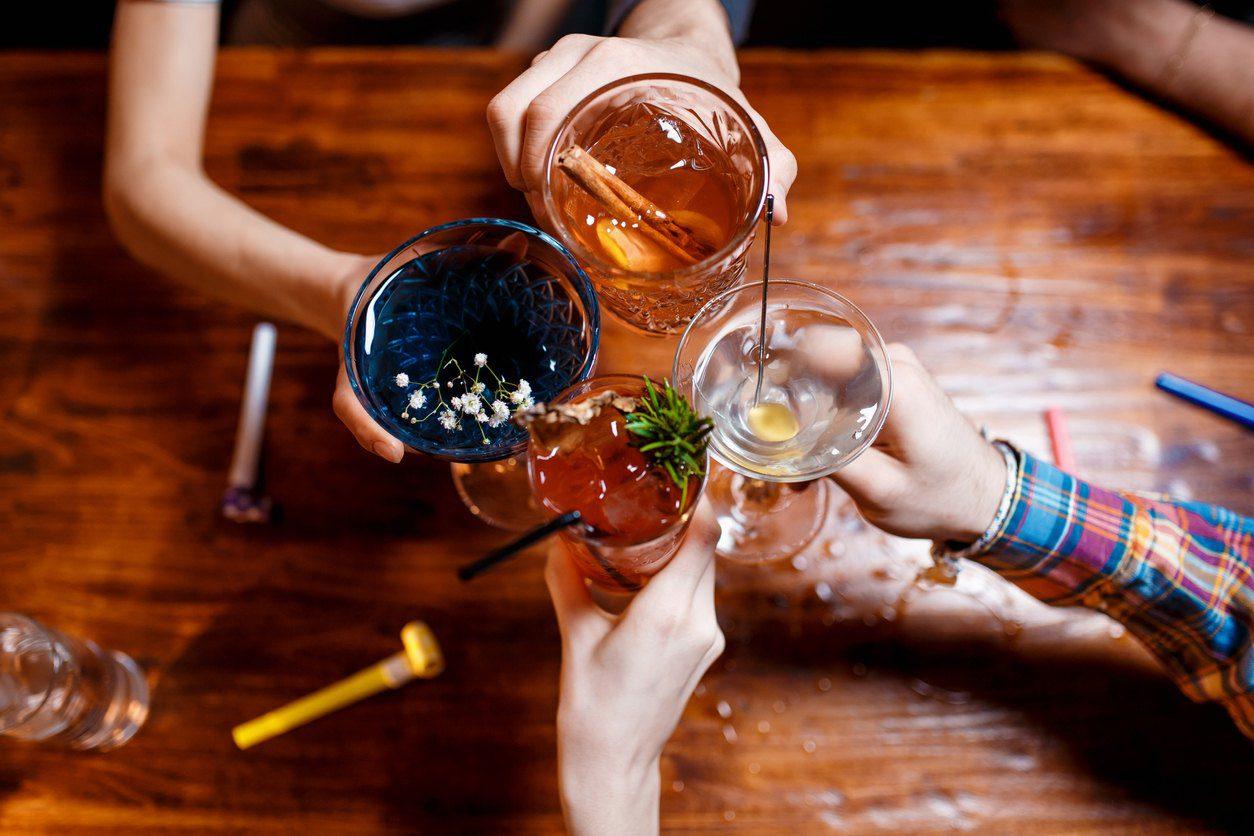 Overhead view of four friends clinking glasses