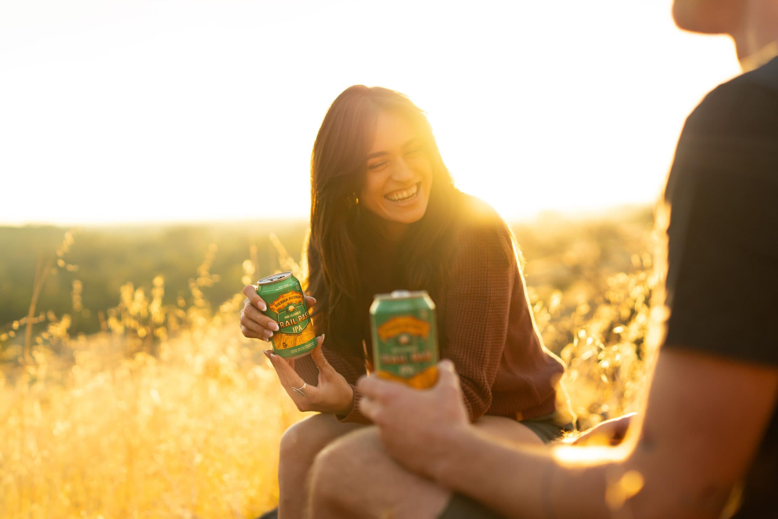 Trail Pass IPA can being held by hikers outside